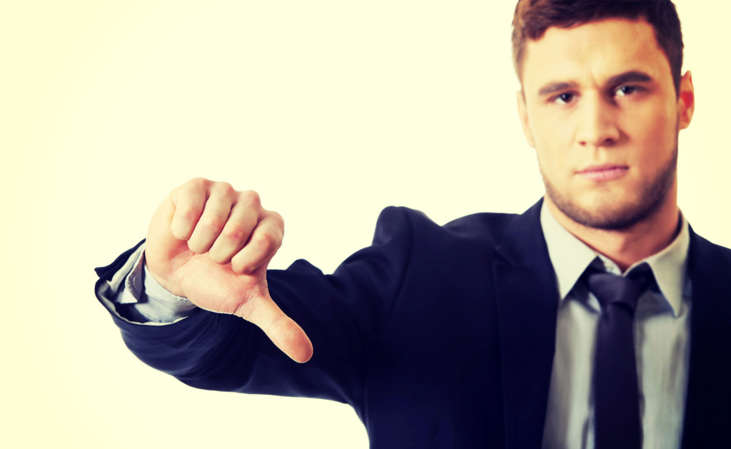 Picture of a person giving a thumbs down sign.
